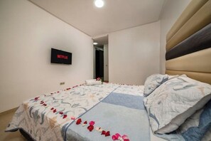 A bedroom with a bed, a wall-mounted TV displaying 'NETFLIX', and a door leading to another room. - Comfort Family 3 Bedrooms | Swimming pool & Fiber & Parking (Agadir)