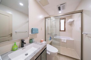 Une salle de bain moderne avec une douche à parois de verre, un lavabo blanc et des toilettes.