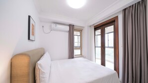 Une chambre d’hôtel avec un lit, une fenêtre et un appareil de climatisation.