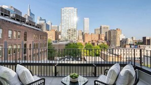 A balcony with a view of a cityscape, including a tall building and other structures. - Where Rock & Roll Royalty Crash - Hot Tub & More (Philadelphia)