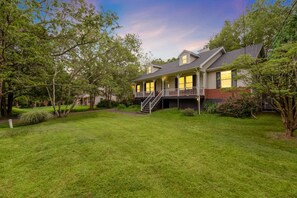 A two-story house with a covered porch and a staircase leading to the upper level. - Lake House: Hottub, Sauna, Firepit, Games! (Albrightsville)