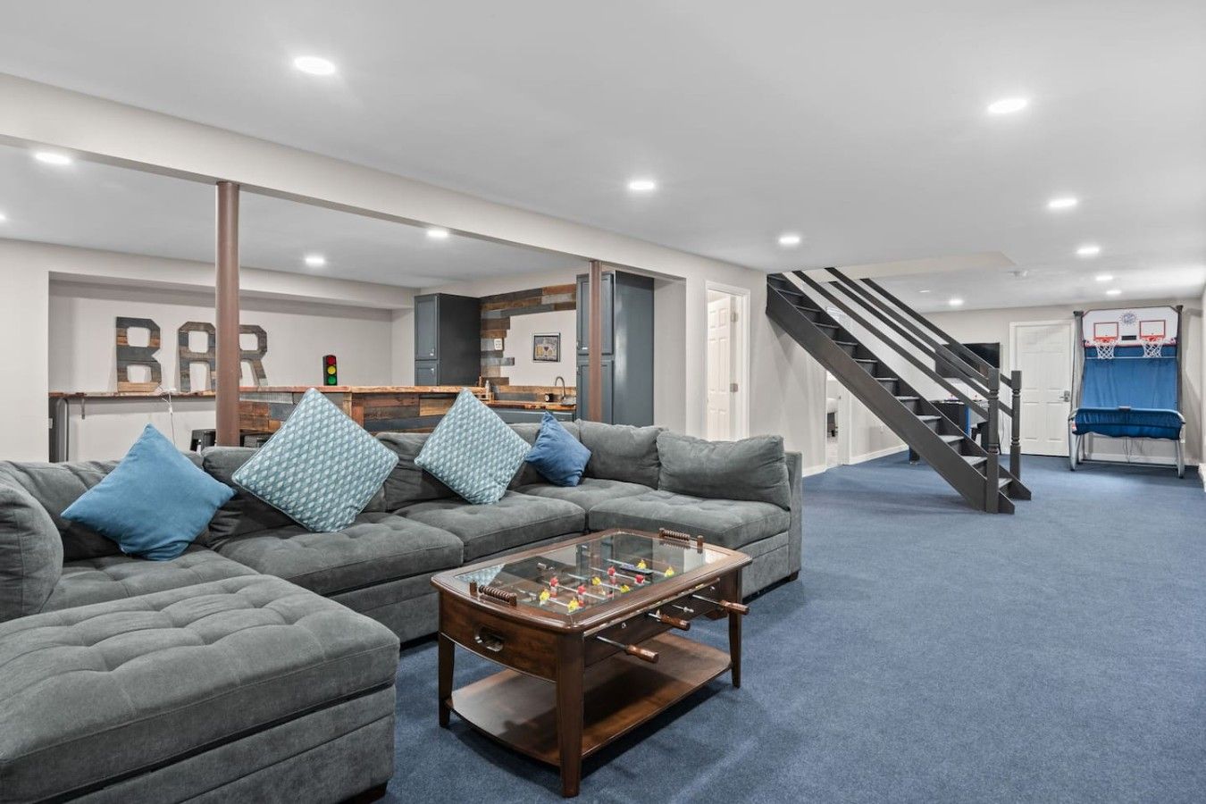 A living room with a sofa, coffee table, and a staircase leading to a second floor.