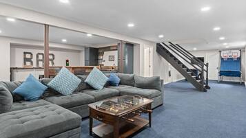 A living room with a sofa, coffee table, and a staircase leading to a second floor.