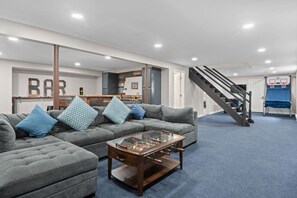 A living room with a sofa, coffee table, and a staircase leading to a second floor.