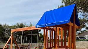 A playground with a yellow slide and a climbing structure. - Beachside Holiday Home Marija (Lozice)