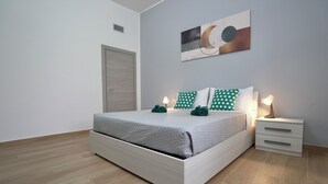 A modern bedroom with a bed, nightstands, and a wall art piece. - Maison 54 - Canneto Lake (Brescia)