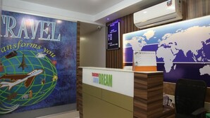 Un comptoir d’accueil orné d’une carte du monde et d’une pancarte sur laquelle on peut lire : « Le voyage vous transforme. »