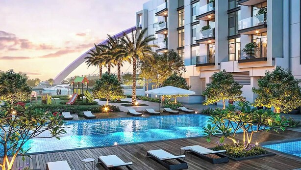A modern hotel with a rooftop pool, lounge chairs, and a children's play area.