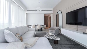 A modern living room with a sofa, a coffee table, and a TV.