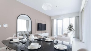 A modern living room with a dining area set for a meal.
