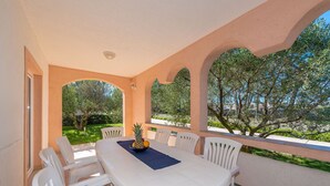 An outdoor patio with a white table and chairs, a blue placemat, and a fruit bowl. - Beachside Holiday Home Manuela (Lozice)