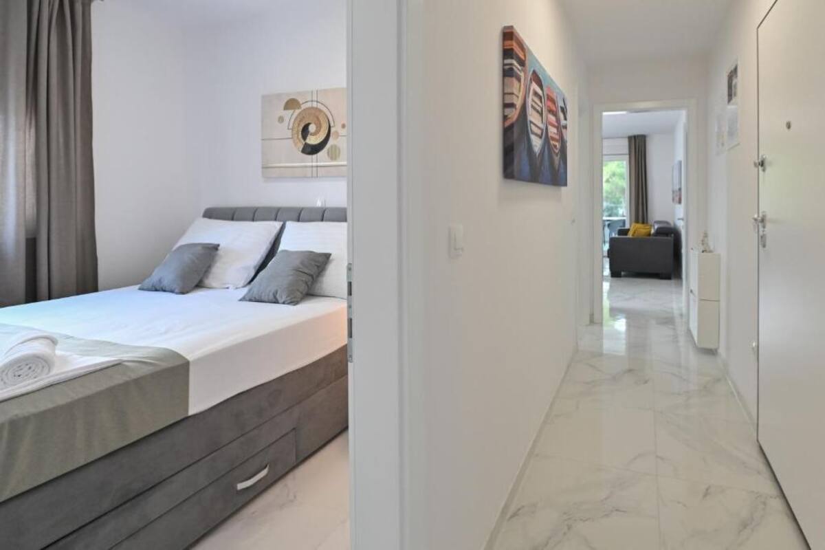 A modern bedroom with a bed, a headboard, and a painting on the wall.