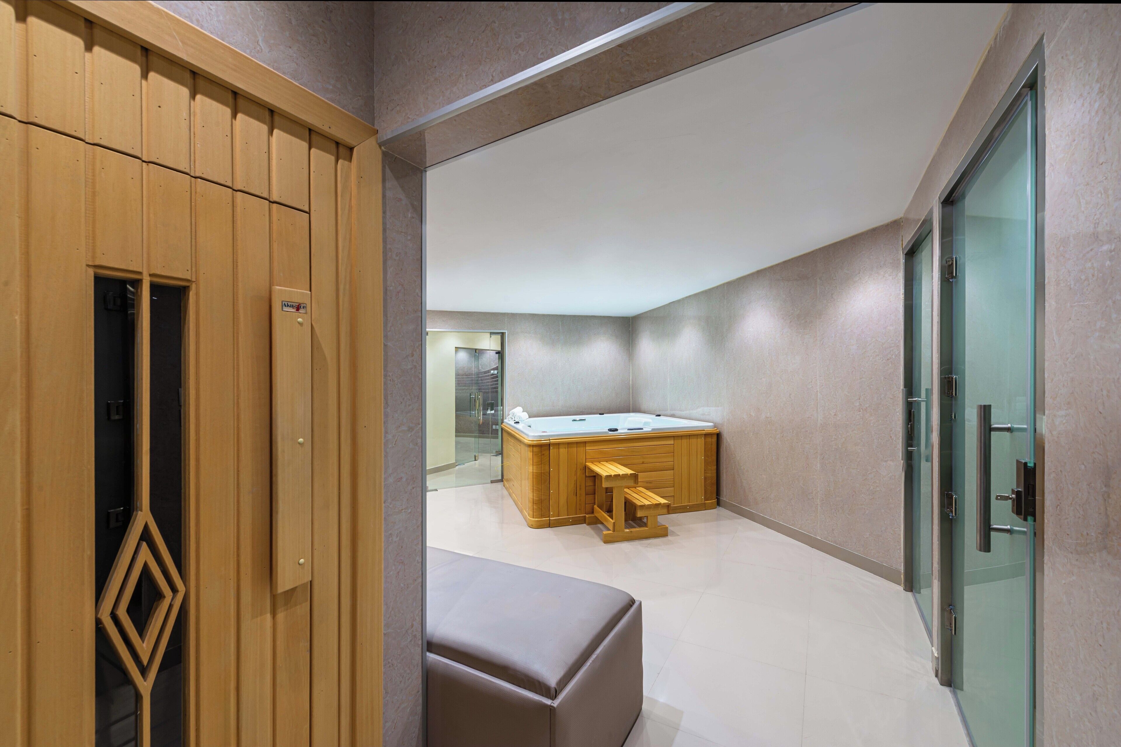 Un baño moderno con tocador de madera, cabina de ducha de vidrio y suelo de mármol.