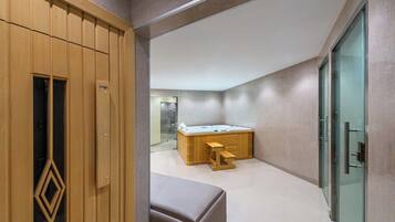 Un baño moderno con tocador de madera, cabina de ducha de vidrio y suelo de mármol.