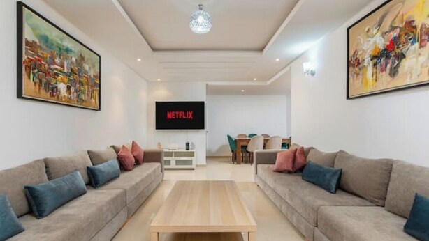 A modern living room with two sofas, a coffee table, a TV, and artwork on the walls.