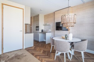 A modern kitchen with a dining area featuring a round table and four chairs.