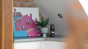 A kitchen counter with a potted plant, a small figurine, and a Krups appliance. - Stylish Apartment with Workspace | Close to the Old Zoo (Poznań)