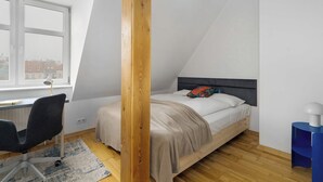 A bedroom with a bed, a desk, and a chair. - Stylish Apartment with Workspace | Close to the Old Zoo (Poznań)