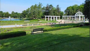 A park with a fountain, a gazebo, and a bench. - Charming Apartment by Lakeside Park | Garden Views (Fort Wayne)