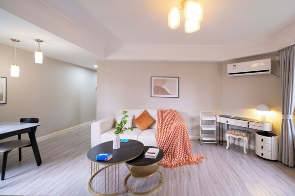 Une chambre d’hôtel moderne comprenant un coin repas, un canapé, un bureau et un appareil de climatisation.