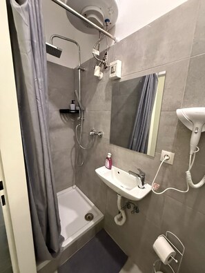 Eenvoudig appartement | Badkamer | Een douche, gratis toiletartikelen, een haardroger, handdoeken
