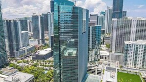 A high-rise urban area with modern skyscrapers, a central building with a glass facade, and surrounding greenery. - Brickell Arch Miami Pool & Free Parking (Miami)