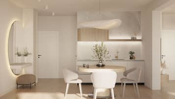 Una cocina moderna con una mesa redonda, sillas blancas y una lámpara colgante.