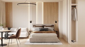 Un dormitorio moderno con cama, mesitas de noche, escritorio y armario.