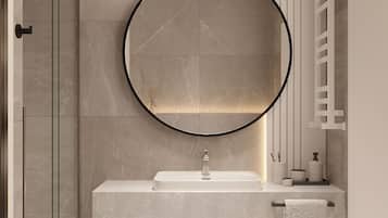 A modern bathroom with a glass shower enclosure, a round mirror, a white sink, and a towel rack.