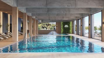 Una piscina interior con vistas despejadas del entorno, que incluye un área de descanso con camas sol y un cartel que dice "STREFA CHILLOUT".