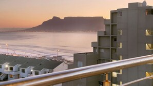 A coastal residential area with modern buildings, a prominent cliff, and a view of the sea. - Ocean View A603 (Cape Town)