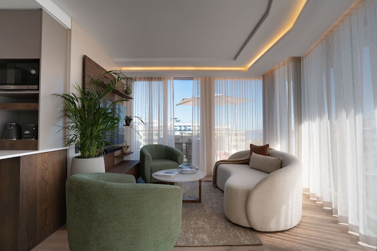 Un salon moderne avec un canapé, un fauteuil et une table basse.