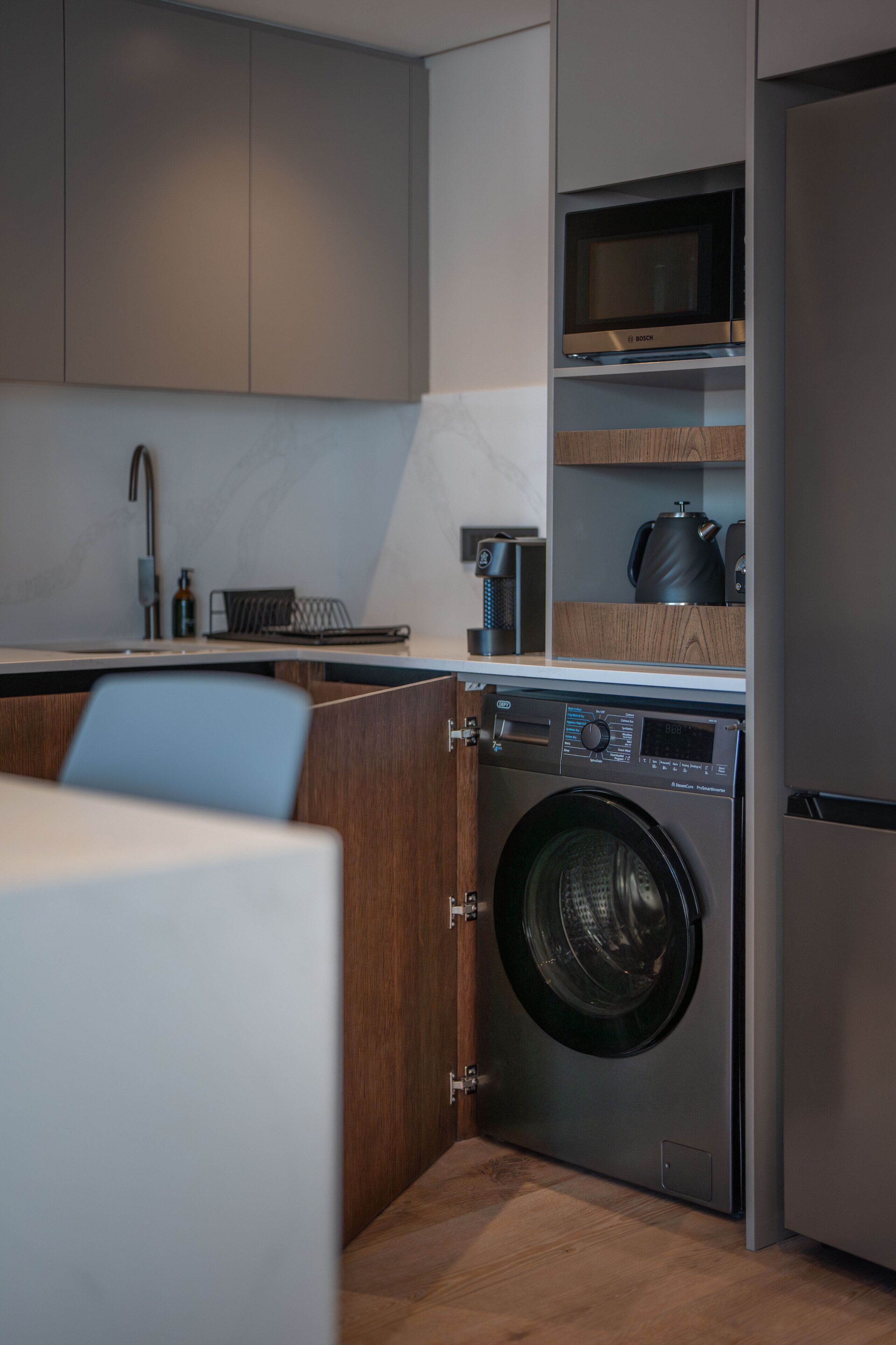 A compact kitchen with a built-in washer, a microwave, and a coffee maker.