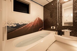 A modern bathroom with a large bathtub, a wall-mounted mirror, and a towel rack.