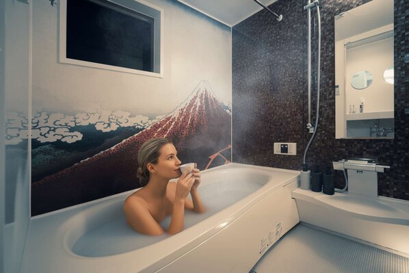 A bathroom with a large bathtub, a mirror, and a wall-mounted heater.