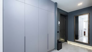 A modern room with grey cabinets, a large mirror, and a tiled floor. - Apartment by Luxe Group KO333 (Yerevan)