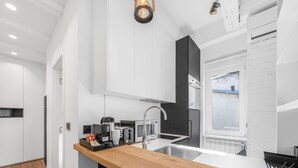 Eine moderne Küche mit einer Holzausziehtheke, Edelstahlgeräten und einem Fenster mit Blick.