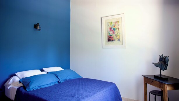A bedroom with a bed, a desk, and a wall-mounted lamp. - Mas de Cerier (Saint-Gilles)