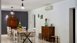 A dining area with a wooden table, white chairs, and pendant lights. - Mas de Cerier (Saint-Gilles)