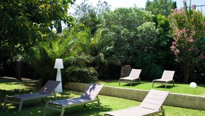 A garden with four lounge chairs and a white lamp post. - Mas de Cerier (Saint-Gilles)