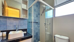 A modern bathroom with a glass-enclosed shower, a sink with a mirror, and a toilet. - Cupe Summer - Porto de Galinhas (Ipojuca)