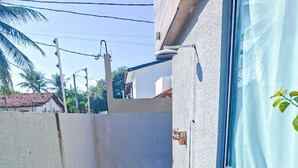 A small outdoor pool area with a blue tiled floor, surrounded by a concrete wall and a glass window. - Cupe Summer - Porto de Galinhas (Ipojuca)