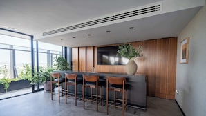 A modern kitchen with a bar area, large windows, and potted plants. - City-view stay near Punto Sao Paulo (Guadalajara)