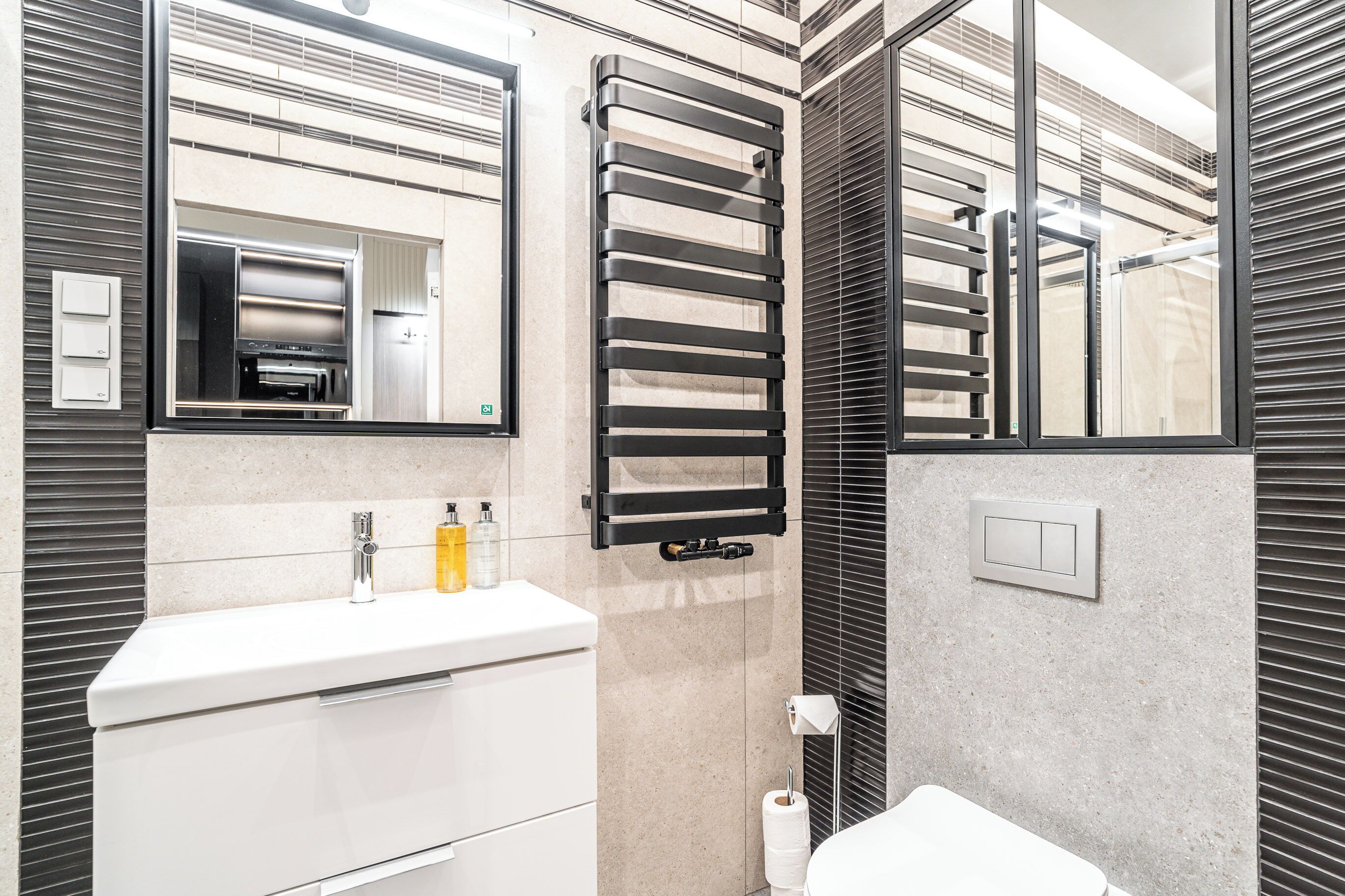 Une salle de bain moderne avec un lavabo blanc, un porte-serviettes et des toilettes.
