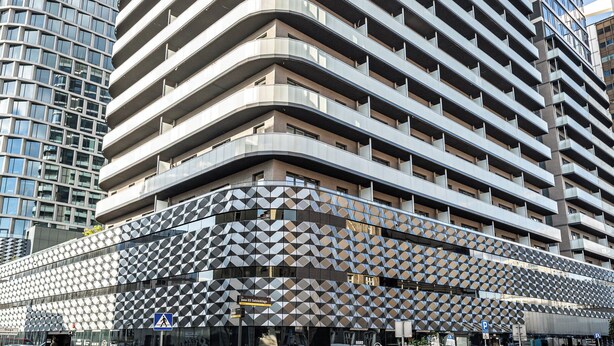 A modern high-rise building with a curved facade, multiple balconies, and a glass exterior. - RentPlanet - Studio Zabrska (Katowice)