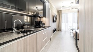 A modern kitchen with a large island, stainless steel appliances, and a dining area with a table and chairs. - RentPlanet - Studio Zabrska (Katowice)