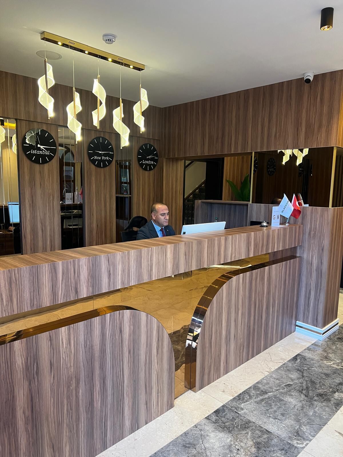 A reception desk with clocks displaying Istanbul, New York, and London times.