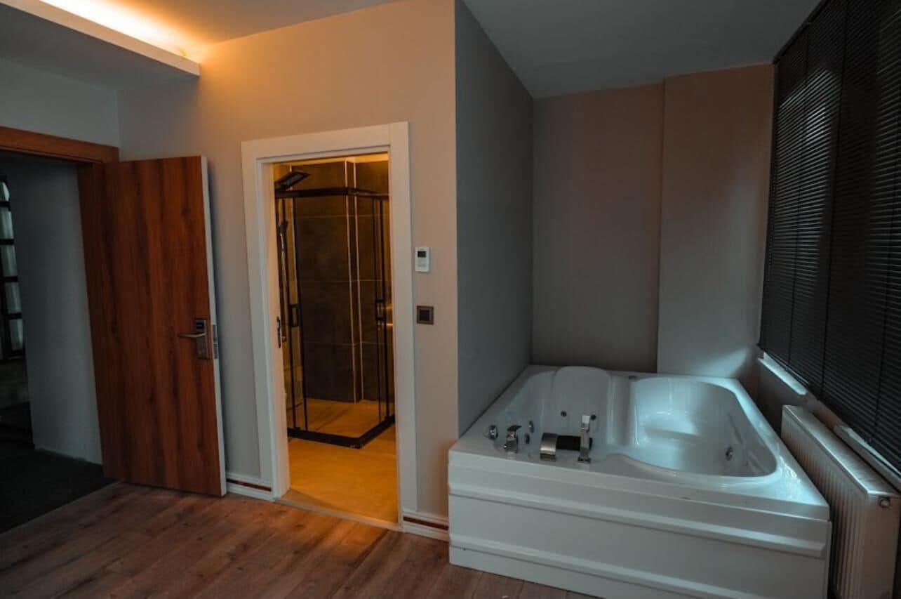 Un baño moderno con cabina de ducha, bañera y retrete.
