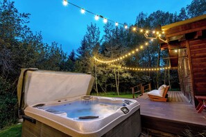 A hot tub on a wooden deck with string lights overhead. - Teton Homestead: Quaking Aspen Escape + Hot Tub (Driggs)