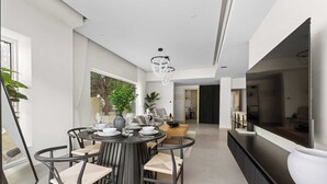 A modern dining area with a round table, chairs, and a large vase. - Arabian Ranches Villa Sleeps 9 Near Golf Courses (Dubai)